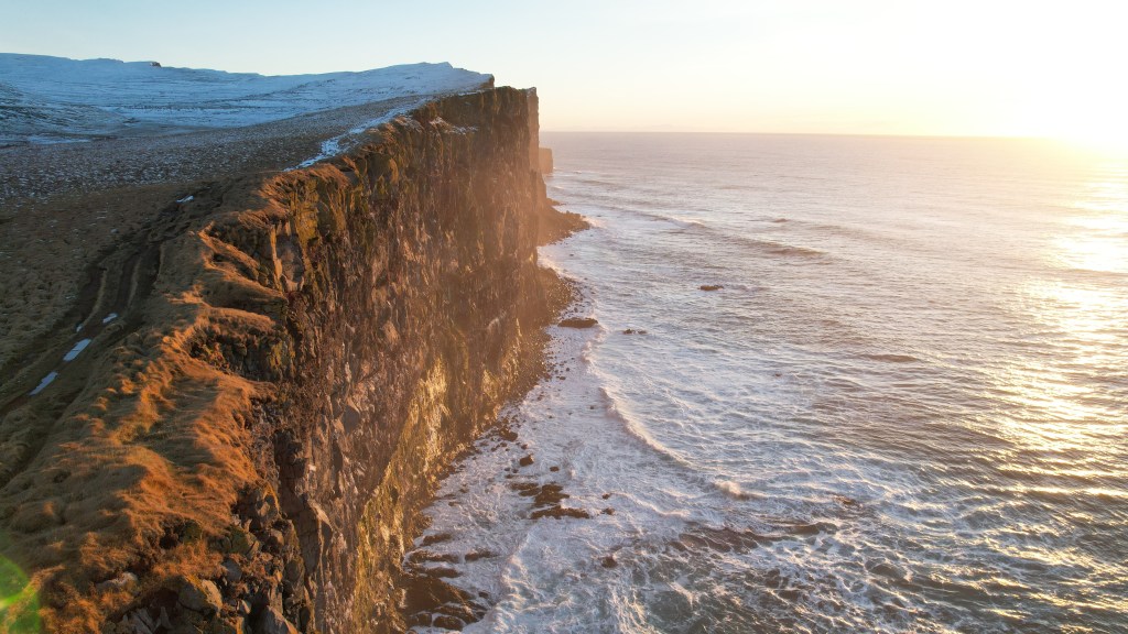 An aerial shot of the Latrabjarg cliffs being hit by the sun in Iceland's Westfjords region